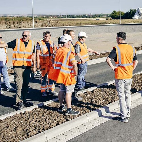 Ingenieure und Bauarbeiter prüfen die neu gebaute Straße